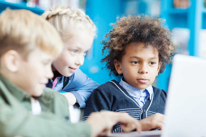 children using a laptop in a classroom