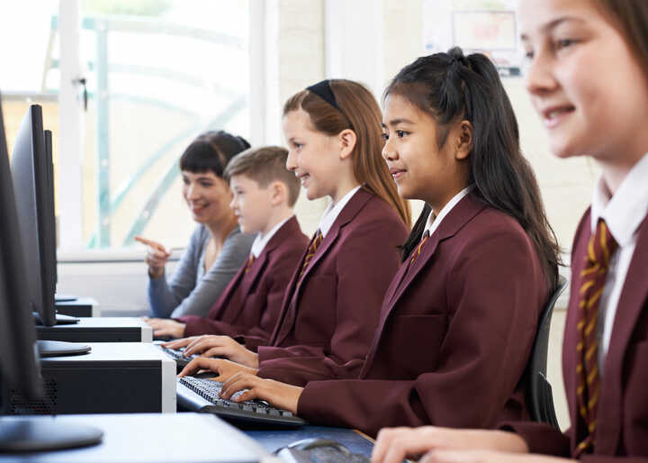 teacher helping students with IT work