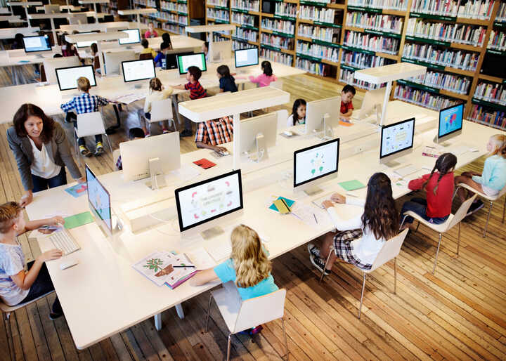 teacher helping students at their computers