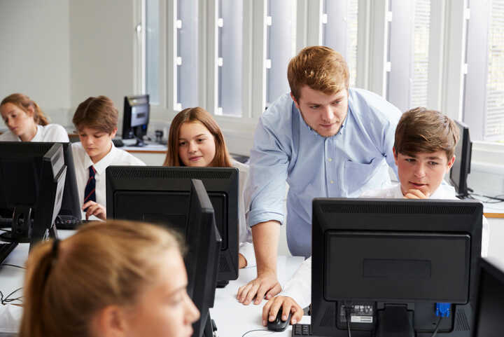 students and teacher sat with a laptop