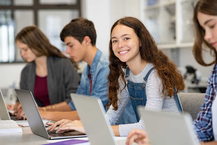 students working at laptops at school