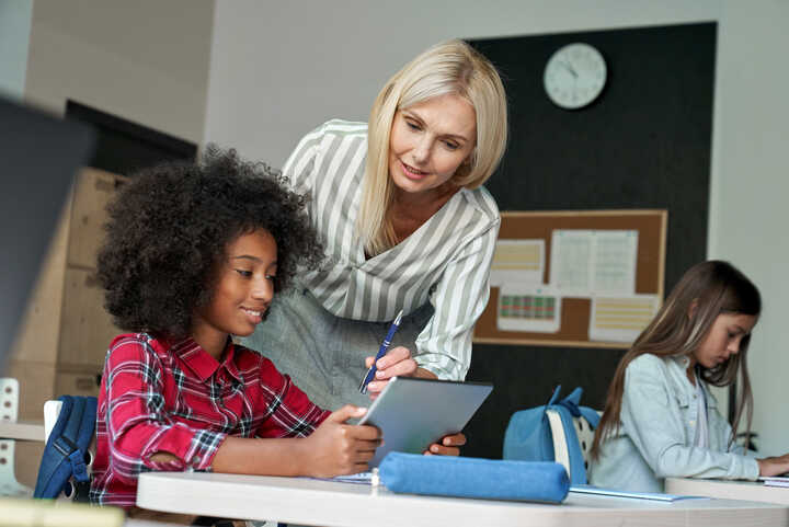 teacher working with students on tablet