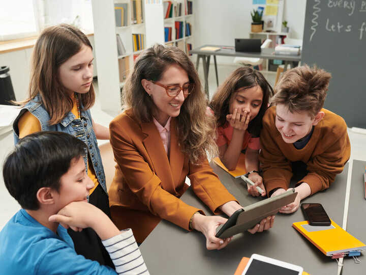 teachers working with students on a tablet