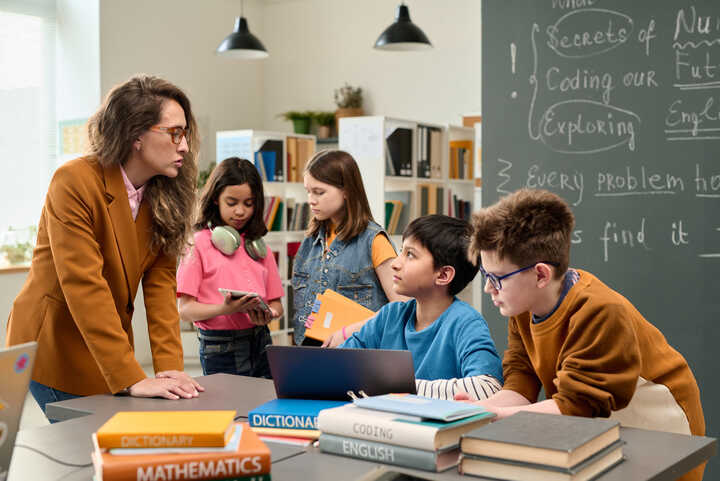 Children and students using laptops and tablets in a classroom