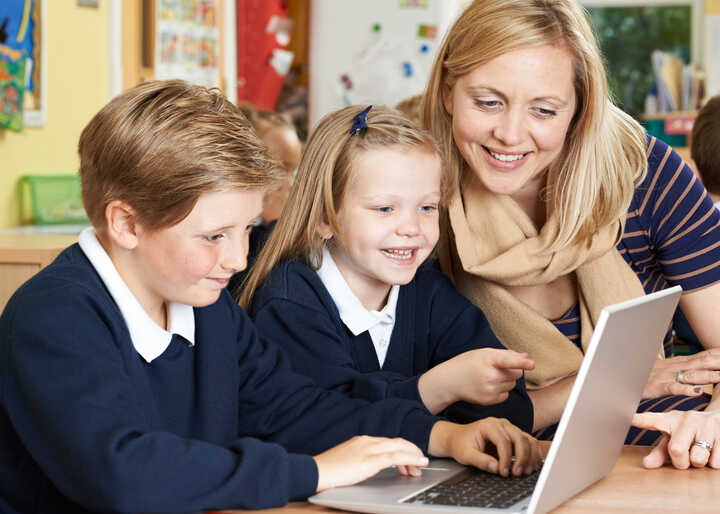 teacher helping students with IT work