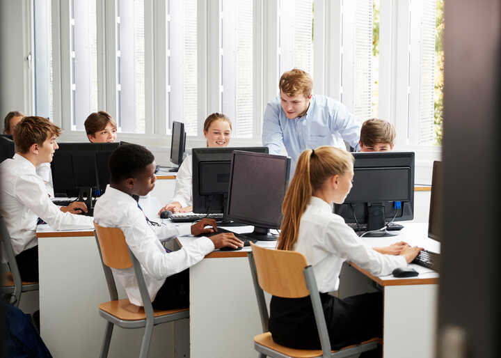 teacher helping students with IT work