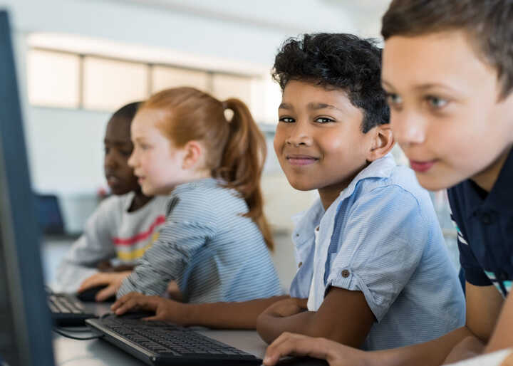 teacher helping students with IT work