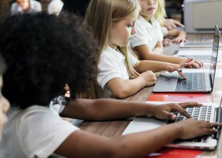 teacher helping students with IT work