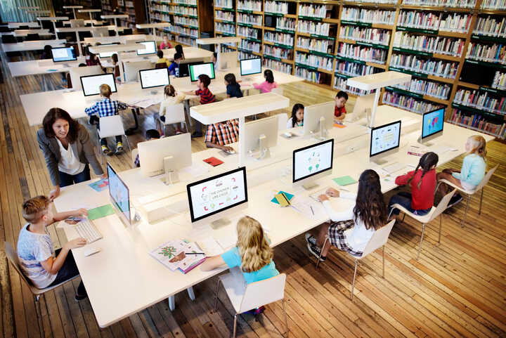 teachers working with students on desktop computers