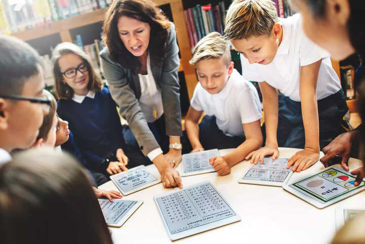 teachers working with students on tablets