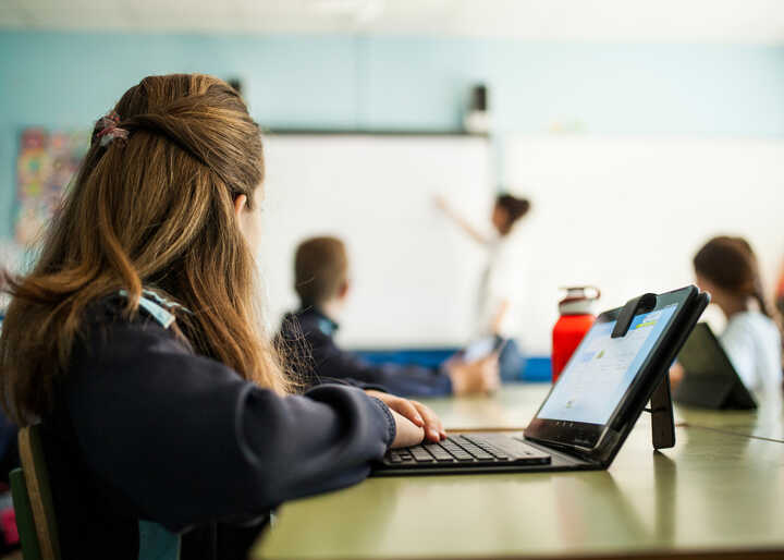 teacher helping students with IT work