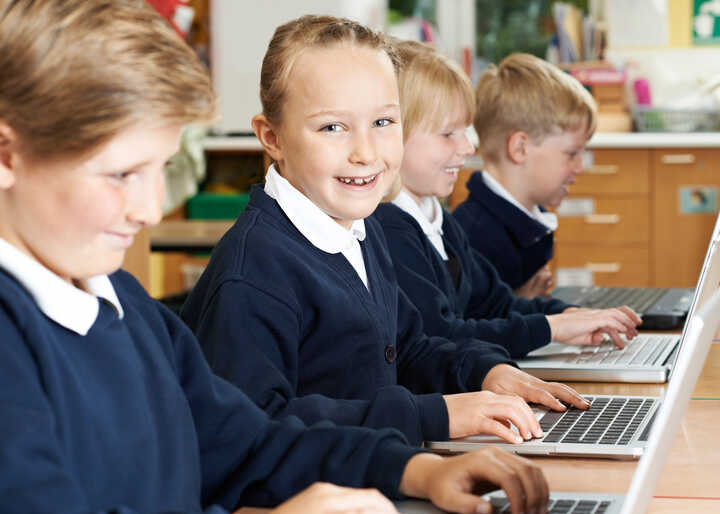 teacher helping students with IT work